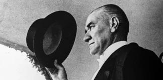 Mustafa Kemal Atatürk, elinde şapkasıyla selam verirken; kararlılığı ve zarafetiyle bir liderin simgesi.